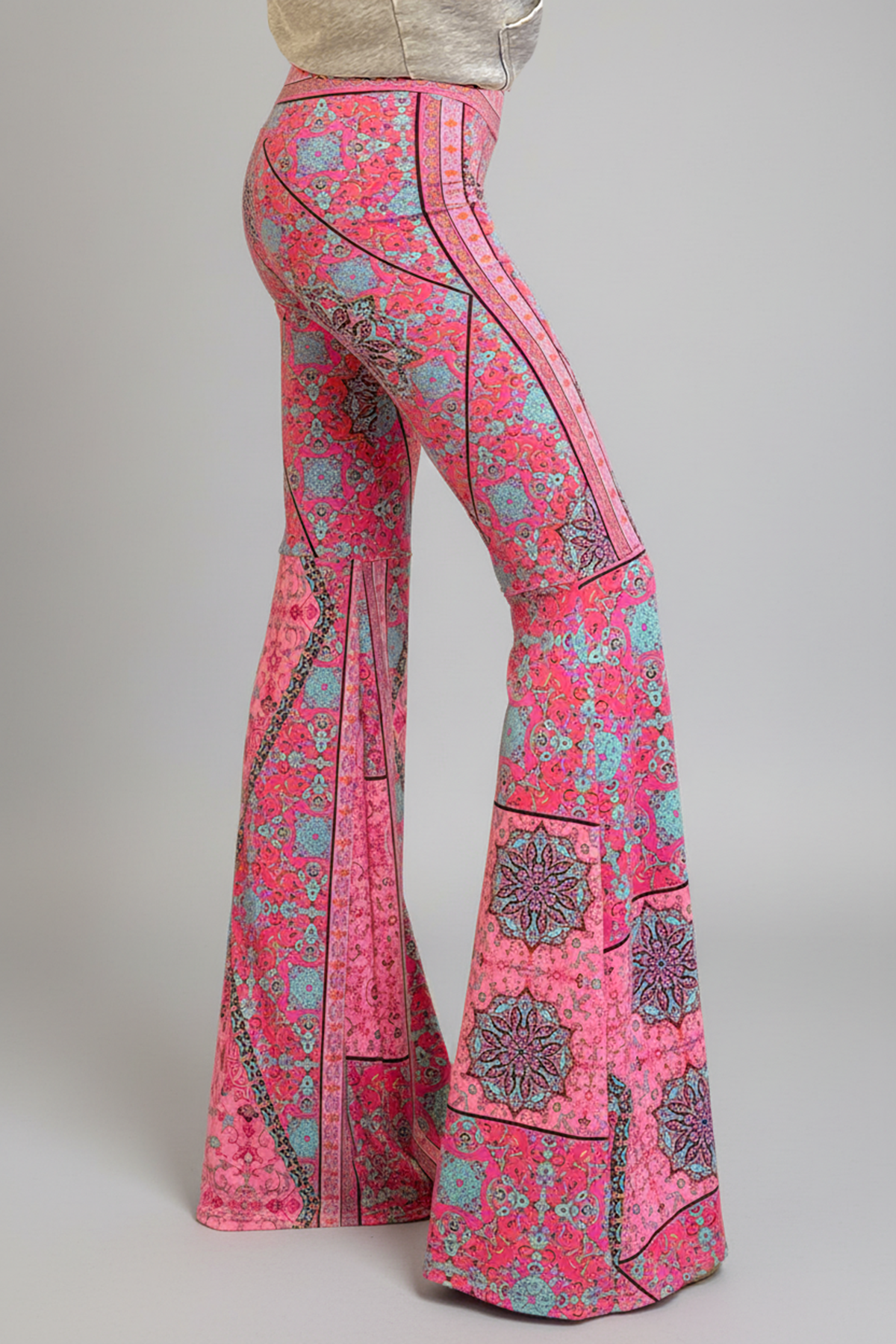 person wearing pink and blue boho print bellbottoms against a grey background